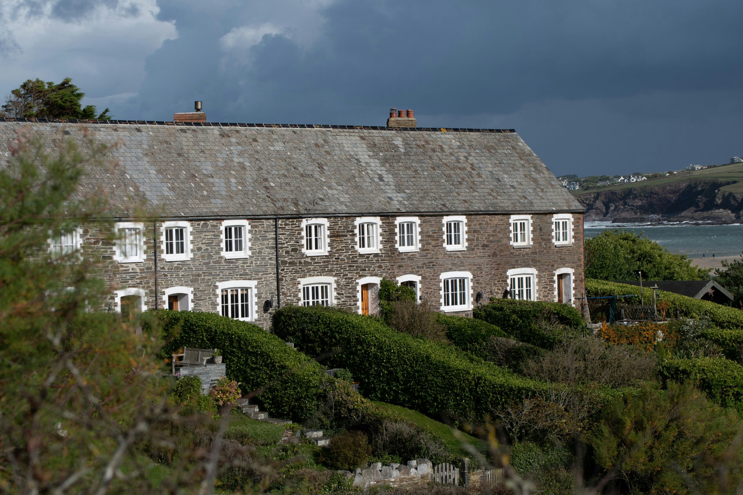 fishermans cottacges in cornwall by the sea against a moody sky